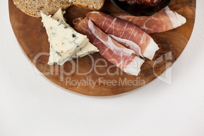 Bread slice, cheese and meat on wooden board