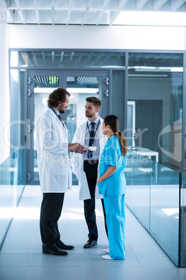 Doctor holding digital tablet having a discussion with colleagues