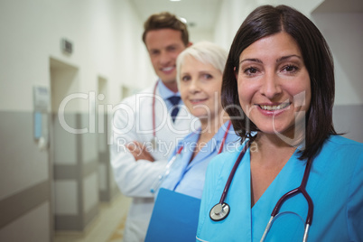 Portrait of female surgeon and doctors standing in corridor