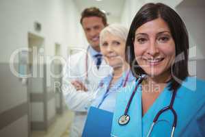 Portrait of female surgeon and doctors standing in corridor