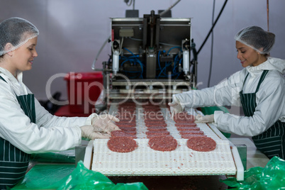 Female butchers processing hamburger patty