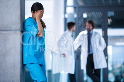 Stressed nurse standing in hospital