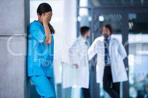 Stressed nurse standing in hospital
