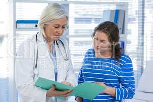 Doctor showing medical report to pregnant woman