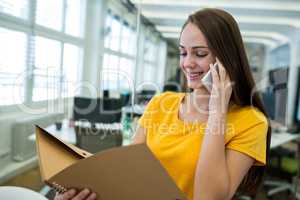 Female business executive talking on mobile phone in office