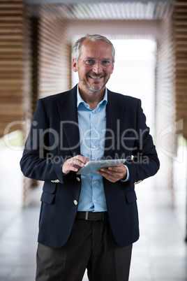 Cheerful businessman holding digital tablet