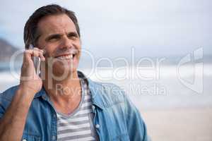 Man talking on mobile phone on beach