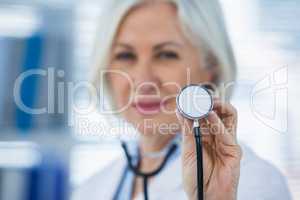 Smiling female doctor showing stethoscope