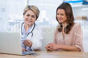 Doctor discussing with patient over laptop