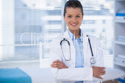 Portrait of a smiling female doctor standing with arms crossed