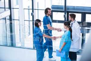 Surgeons, doctor and nurse shaking hands with each other