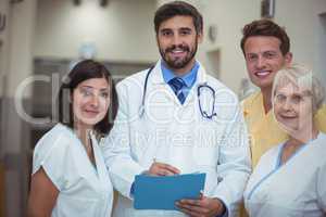 Portrait of doctor and nurse having discussion over file in corridor