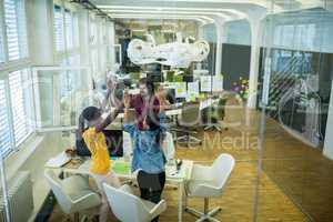 Team of business executives giving high five at desk