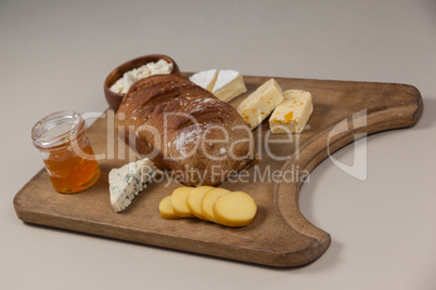 Variety of cheese with bread and sauce on chopping board