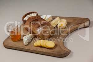 Variety of cheese with bread and sauce on chopping board