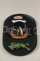 Black cheese with rosemary and salt on serving tray