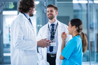 Doctor holding digital tablet having a discussion with colleagues