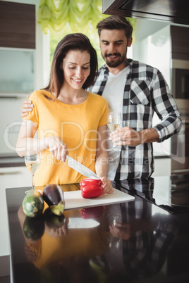 Happy couple chopping vegetables in kitchen