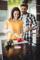 Happy couple chopping vegetables in kitchen
