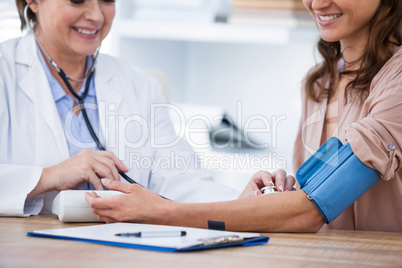 Female doctor checking blood pressure of a patient