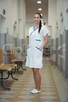 Portrait of female nurse standing in corridor
