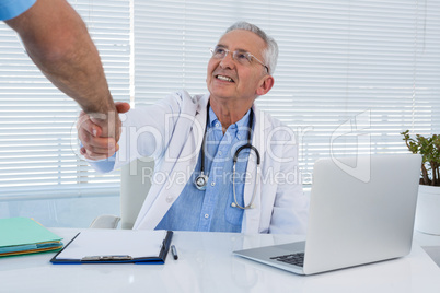 Doctor and surgeon shaking hands