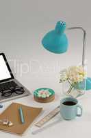 Table lamp, flowers, pebbles, ruler and office desk tops