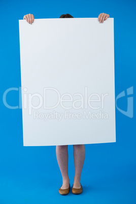 Woman holding a blank placard in front of her face