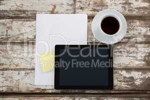 Digital tablet with blank paper and cup of coffee