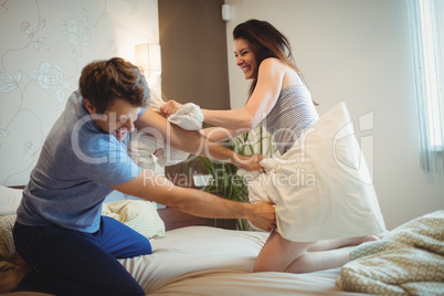 Couple having a pillow fight on bed