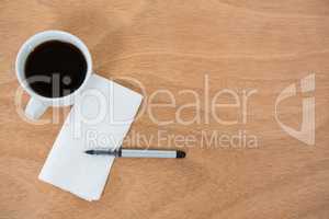 Black coffee with tissue paper and pen