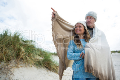 Happy mature couple pointing at view