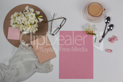Cup of tea, spoons, spectacles, diary, cloth, blank page, paper balls and flowers