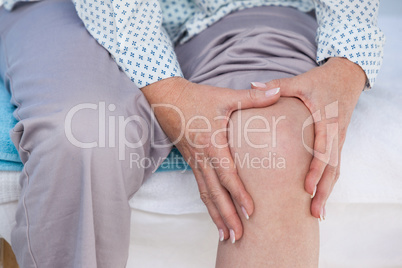 Patient touching her injured knee