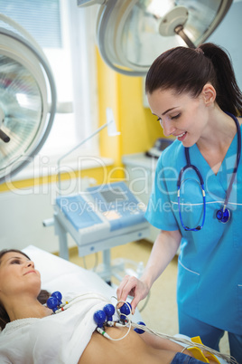 Nurse performing an electrocardiogram test on the patient