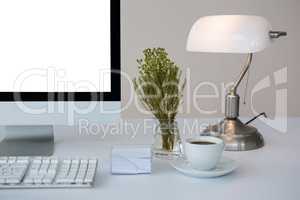 Desktop pc with coffee and table lamp on table