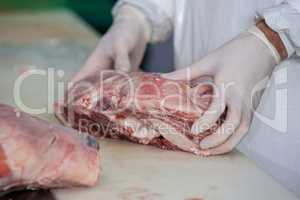 Butcher holding raw meat at meat factory