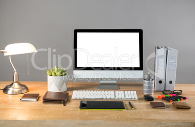 Desktop pc with table lamp and office stationery