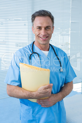 Portrait of smiling surgeon standing with file