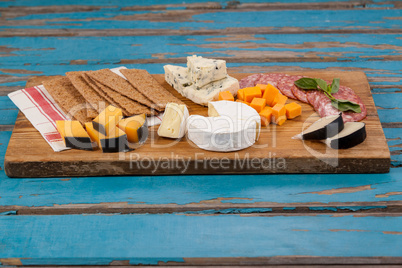 Cheese with ham and crispy biscuits on chopping board