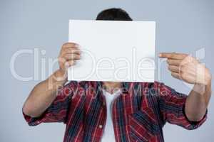 Man holding a blank placard in front of his face