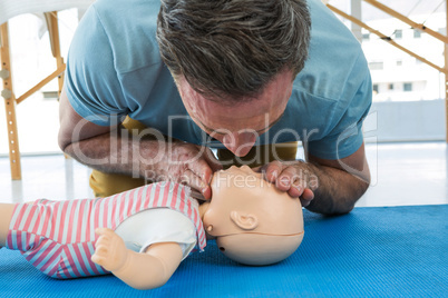 Paramedic blowing oxygen to dummy