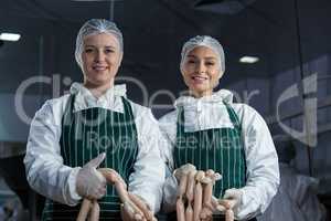 Female butchers processing sausages
