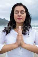 Woman performing yoga on beach