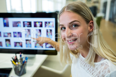 Female business executive pointing at computer screen