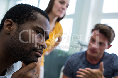 Graphic designers discussing with each other while working