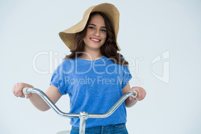 Beautiful woman in blue top and hat holding bicycle