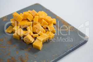 Cheddar cheese slices on cutting board