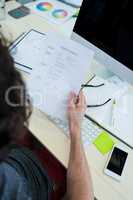 Business executive holding document at his desk