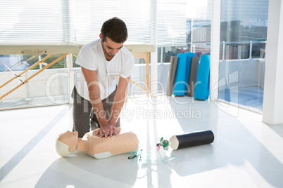 Paramedic practicing resuscitation on dummy